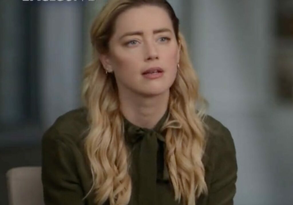 Amber Heard wears her hair down and a green shirt in an NBC interview