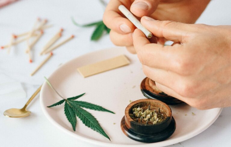 A hand rolling a marijuana joint