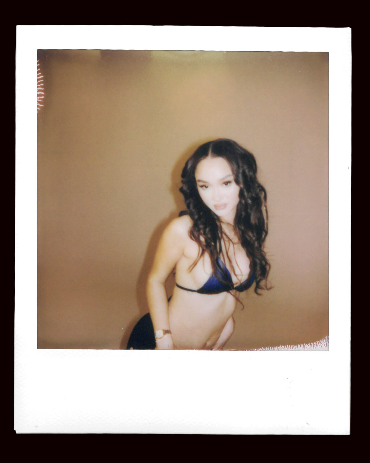 FLO's Stella Quaresma poses in a bikini top for a polaroid picture
