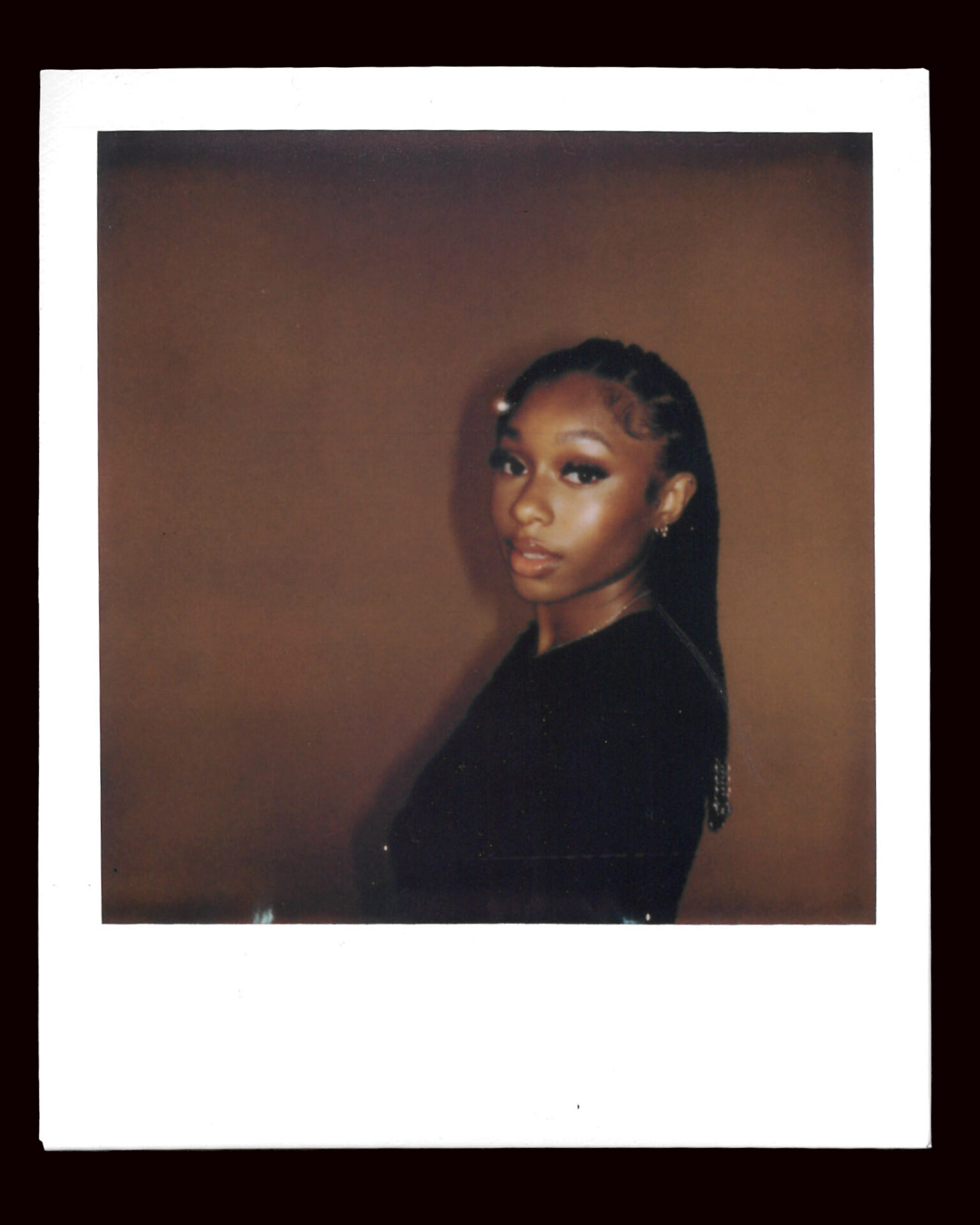 FLO's Renée Downer poses in a black shirt in a side on polaroid picture