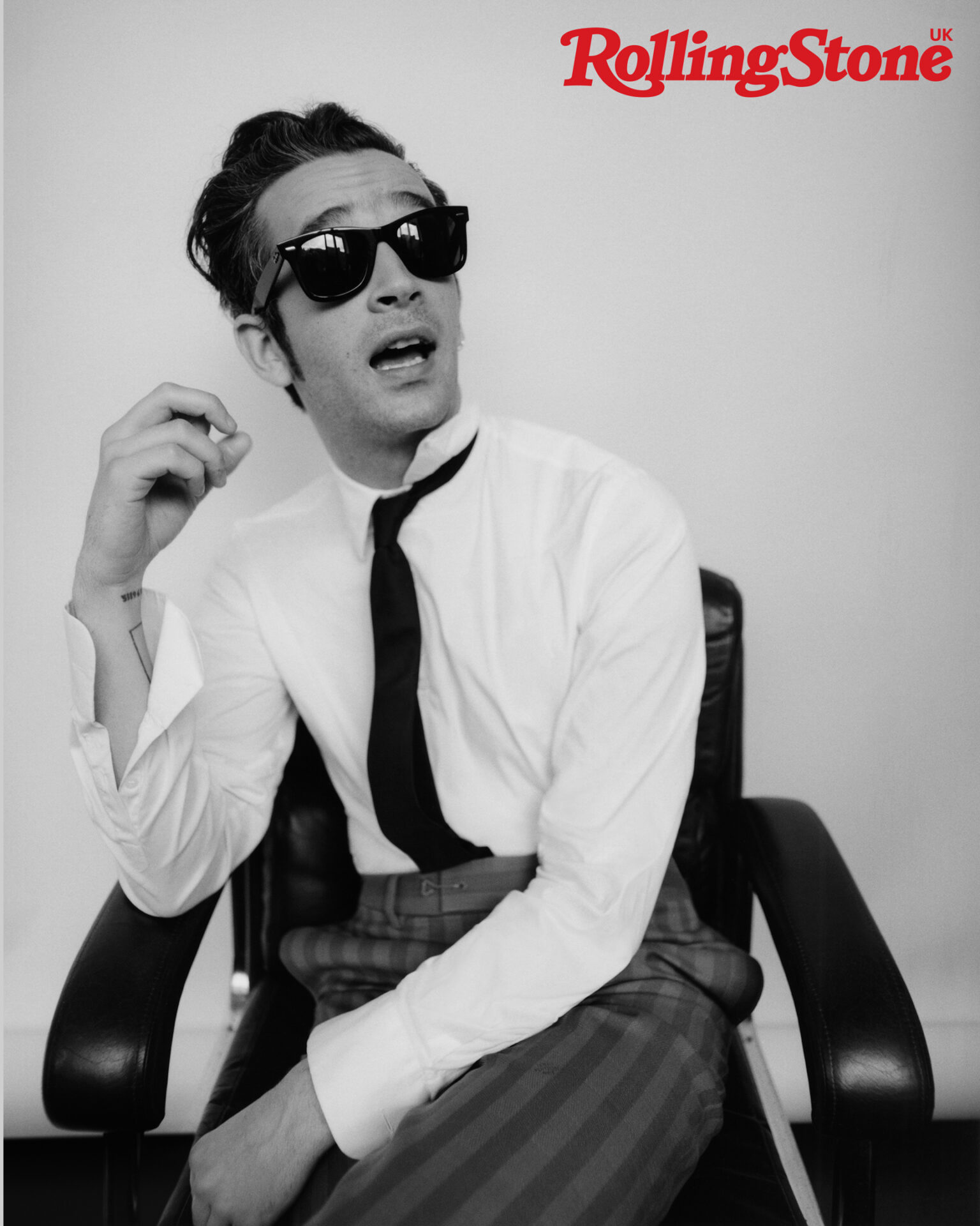 The 1975’s Matty Healy photographed for the cover of Rolling Stone UK. Matty wears vintage shirt by Prada, vintage tie, Matty’s own, trousers by Louis Vuitton, shoes by John Lobb and sunglasses by Ray-Ban