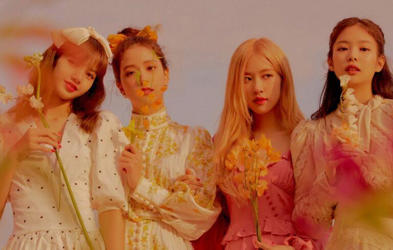 Blackpink hold flowers in a pink-tinged press shot