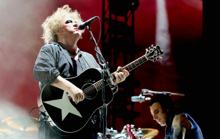 Robert Smith of The Cure performs live playing an acoustic guitar with a star sticker on it