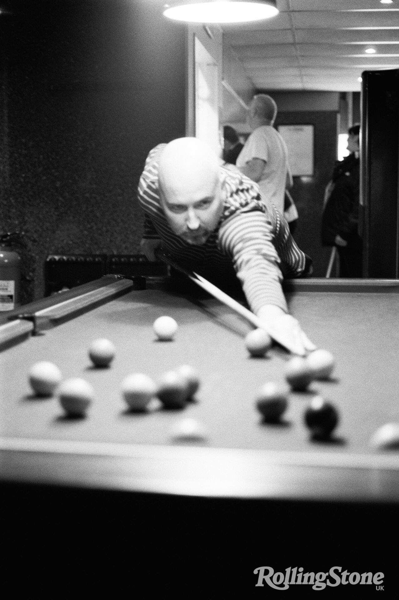 A photograph of author Douglas Stuart playing pool