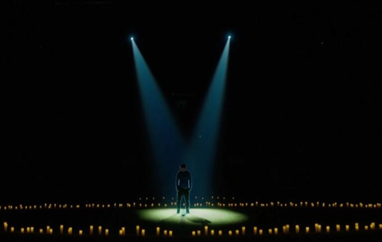 Ed Sheeran stands in an empty Stamford Bridge surrounded by candles