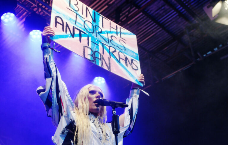 Bimini holds up an anti-Tory placard on the Greenpeace stage at Glastonbury Festival, June 22, 2023