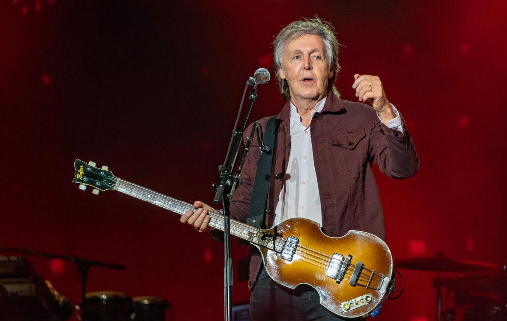 Paul McCartney performs live wearing a burgundy jacket