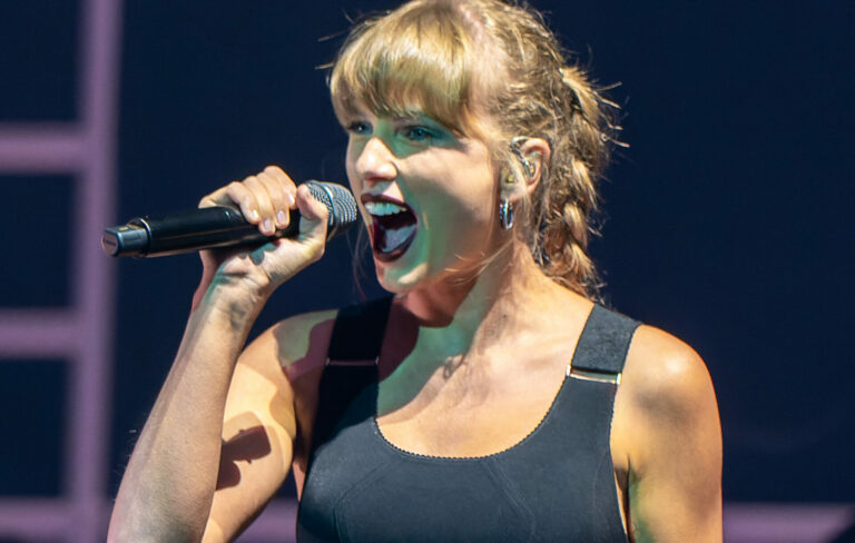 Taylor Swift performs live wearing a black crop top