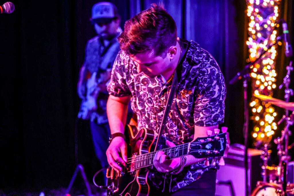 A man playing a guitar onstage