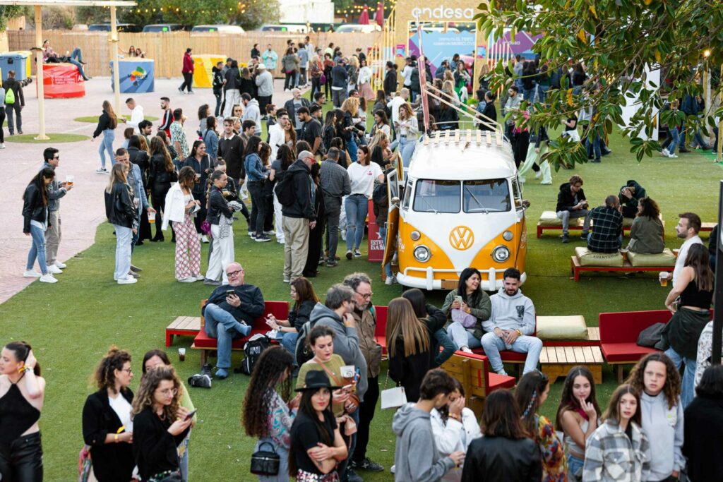 People relax on grass by a VW camper van