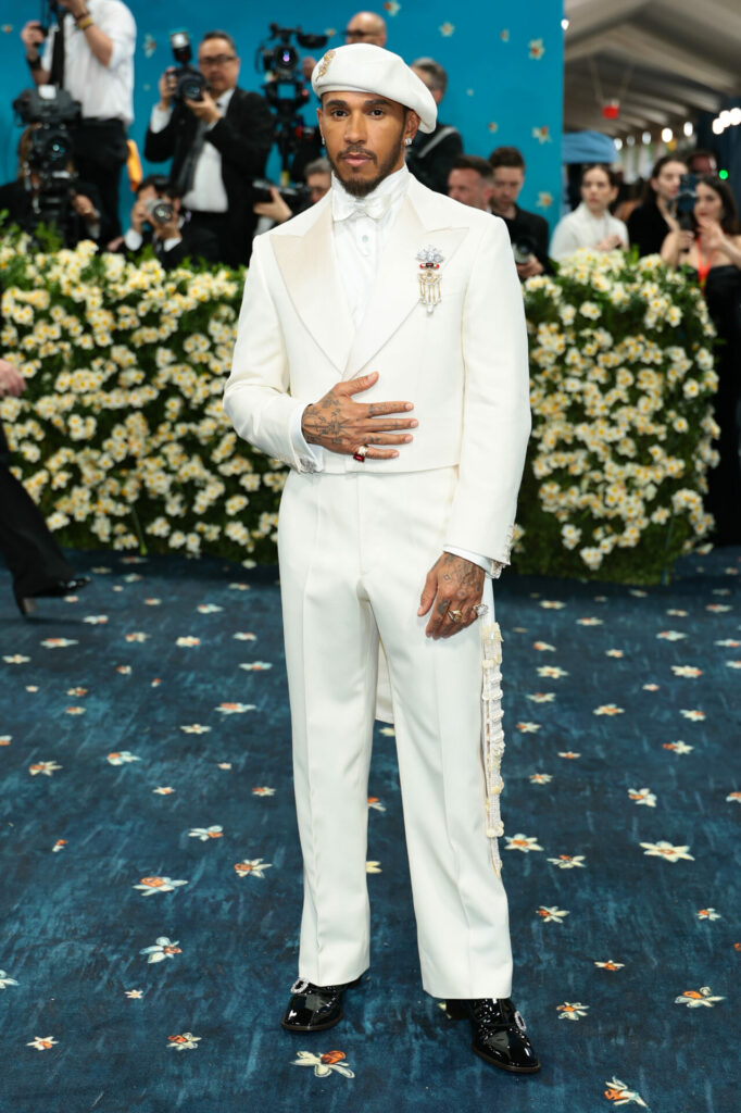 Lewis Hamilton wears white suit with pearl details and jewelled brooches, white bow tie and beret