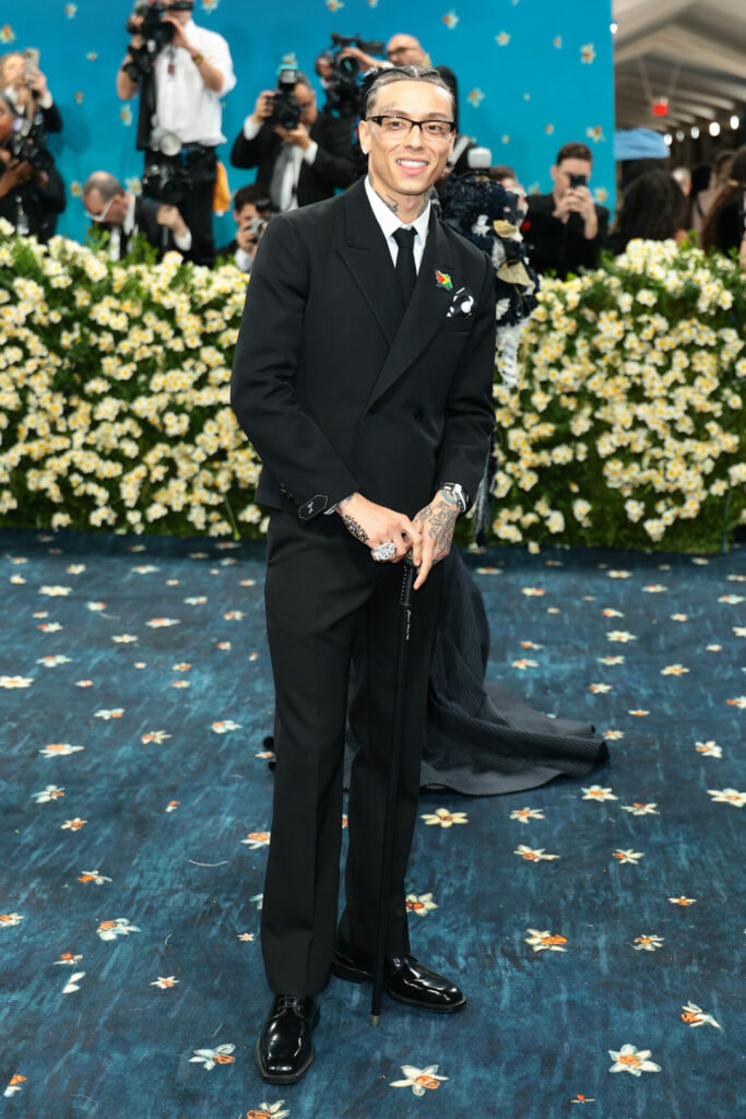 Central See wears custom black Jacquemus suit and tie