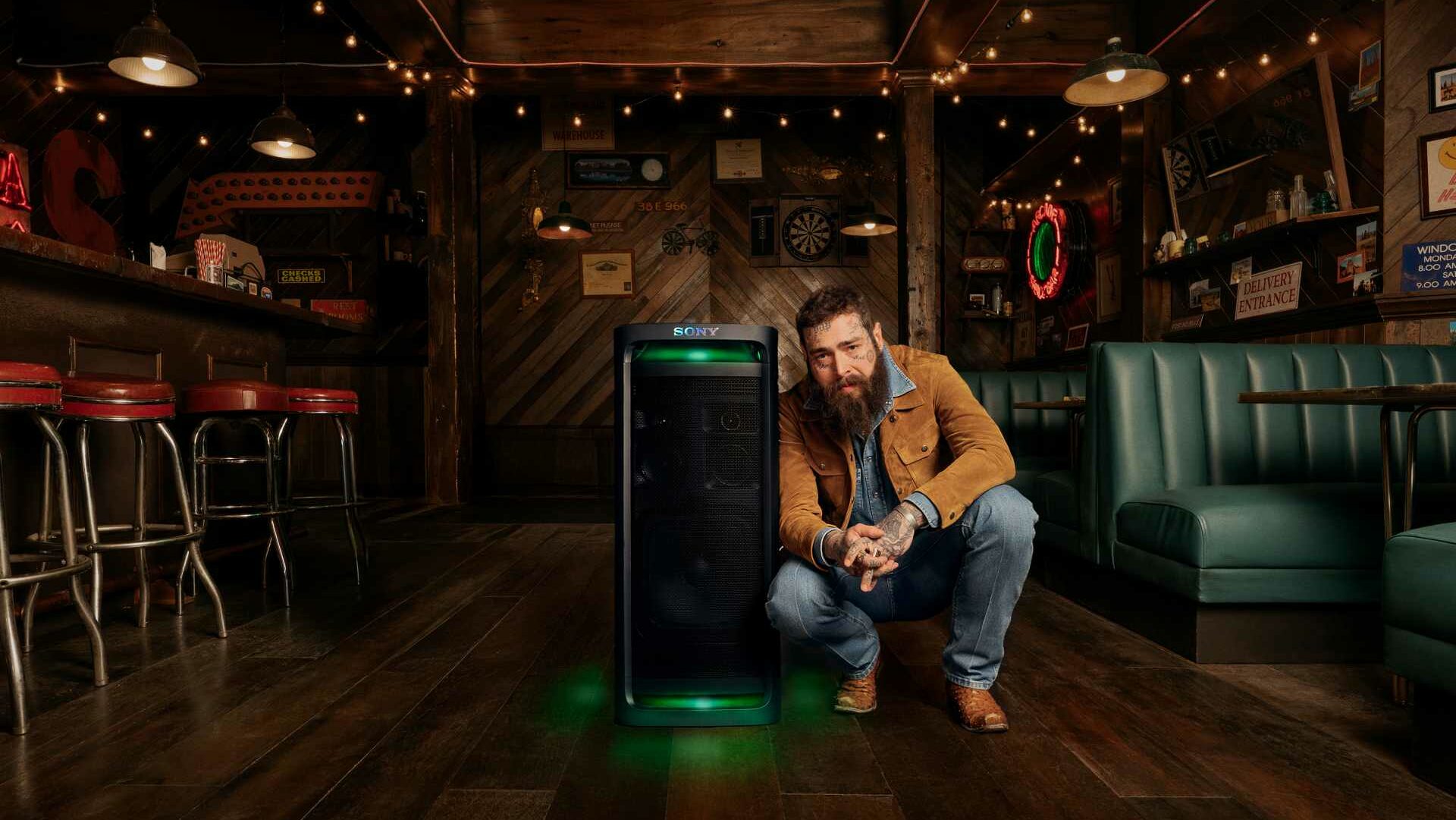 Post Malone standing next to a tower speaker by Sony