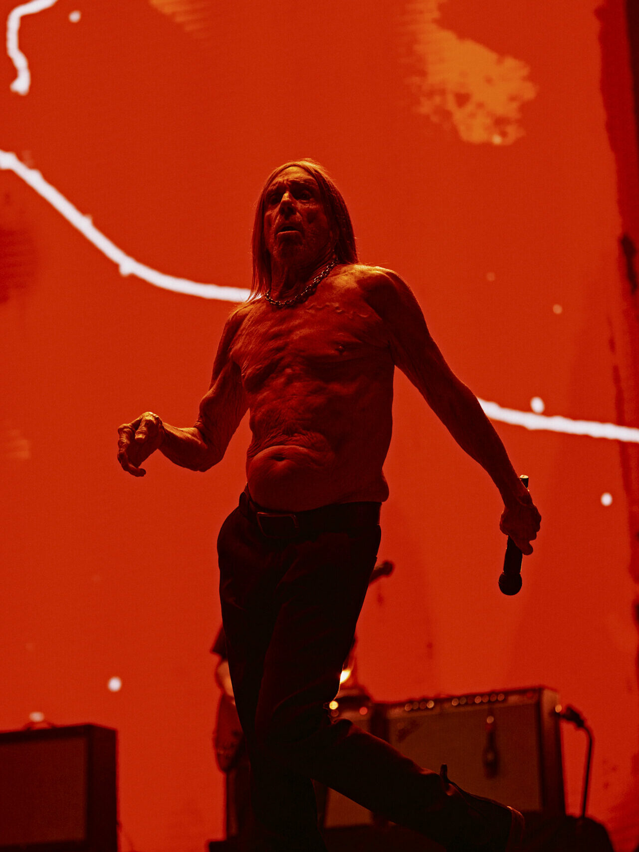Iggy Pop performs shirtless against a red backdrop at Mallorca Live Festival 2025.