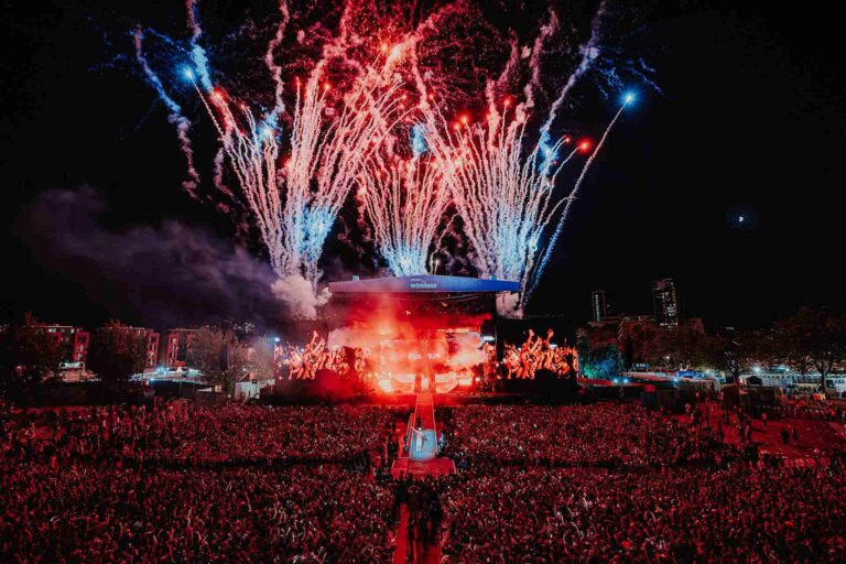 The Wireless Festival stage at night with fireworks in the background and a huge crowd of people in front