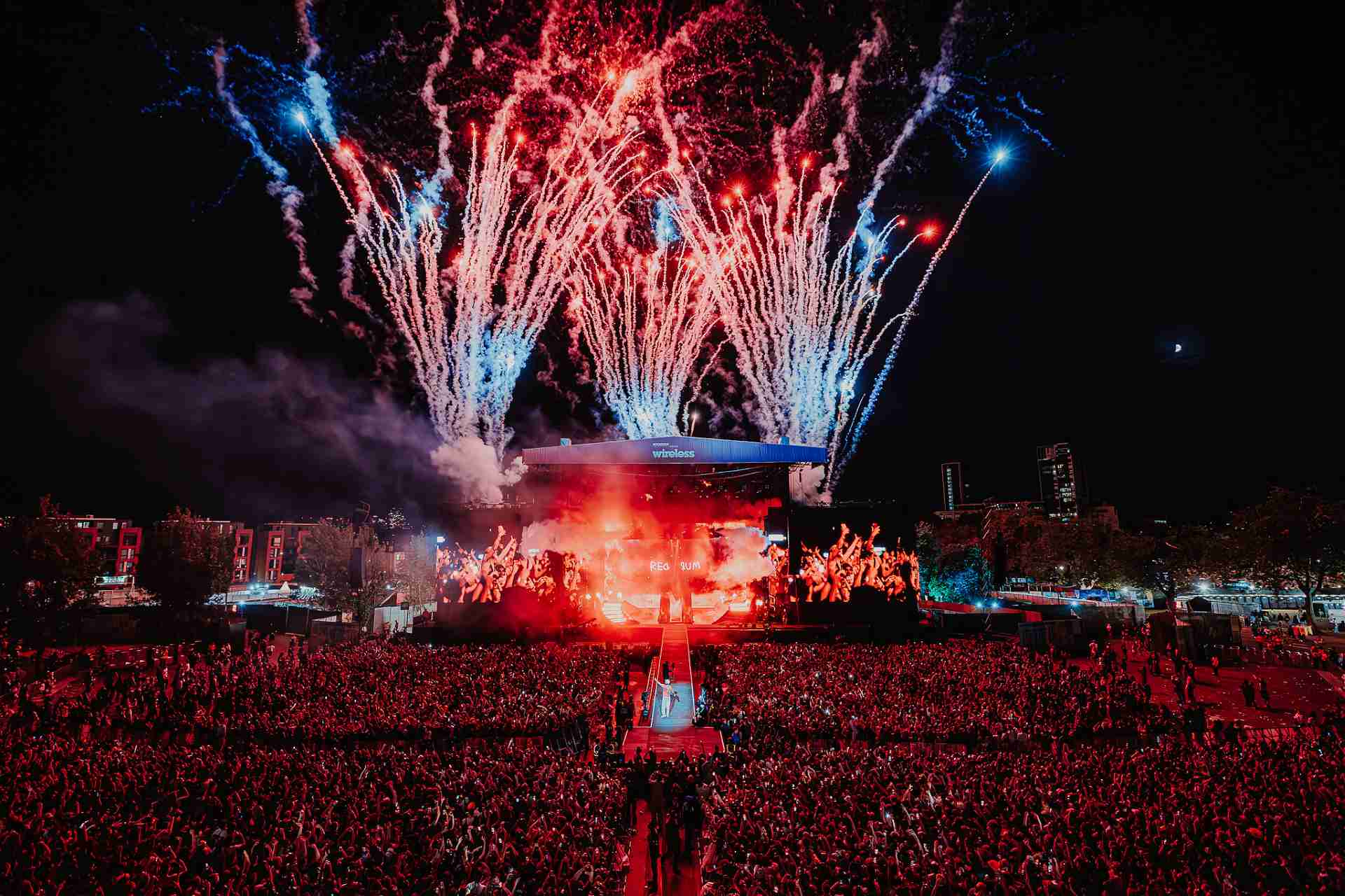 The Wireless Festival stage at night with fireworks in the background and a huge crowd of people in front