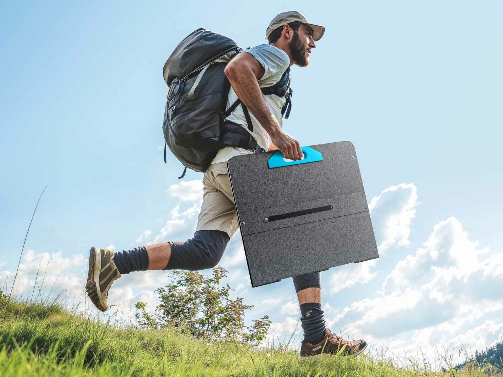 A man carrying a folded solar panel