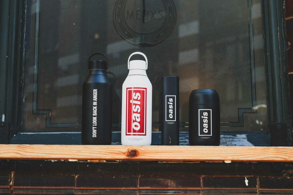 A collection of Oasis-branded water bottles sitting on a window ledge