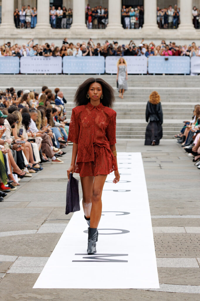 A model wearing a burgundy red, lace set walks the Topshop autumn/winter 2025 show in Trafalgar Square.
