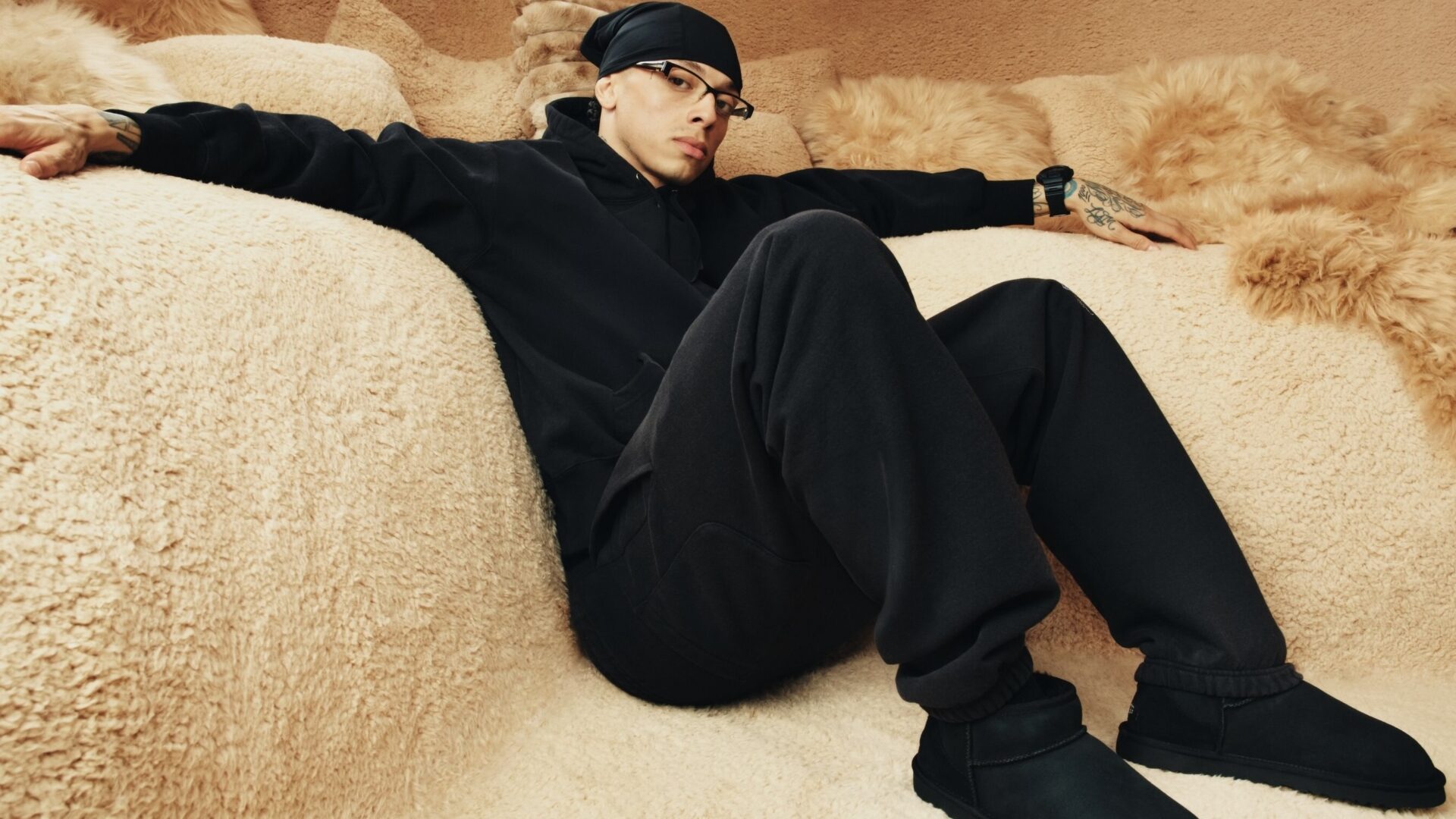 Rapper Central Cee sitting on sheepskin sofas as part of UGG's autumn/winter 2025 campaign.