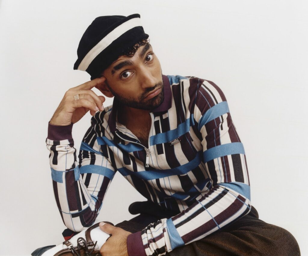 Mawaan Rizwan with his hand on his face posing for a photoshoot