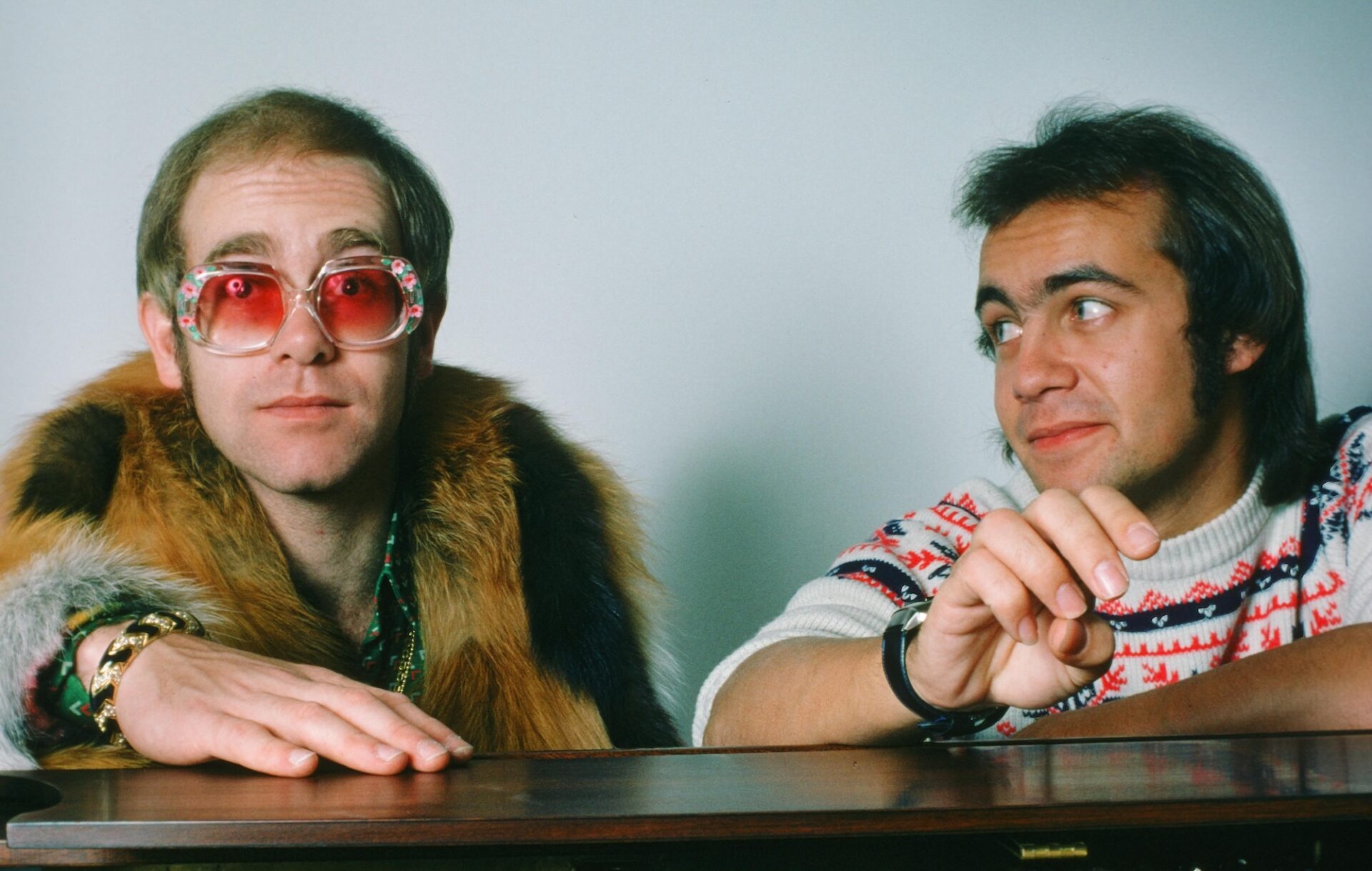 Elton John and Bernie Taupin sat behind a piano for a press photo