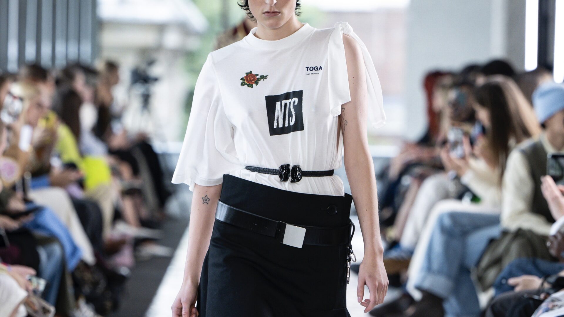 A close-up of the NTS Radio collaboration T-shirt at TOGA Spring/Summer 2026 runway show