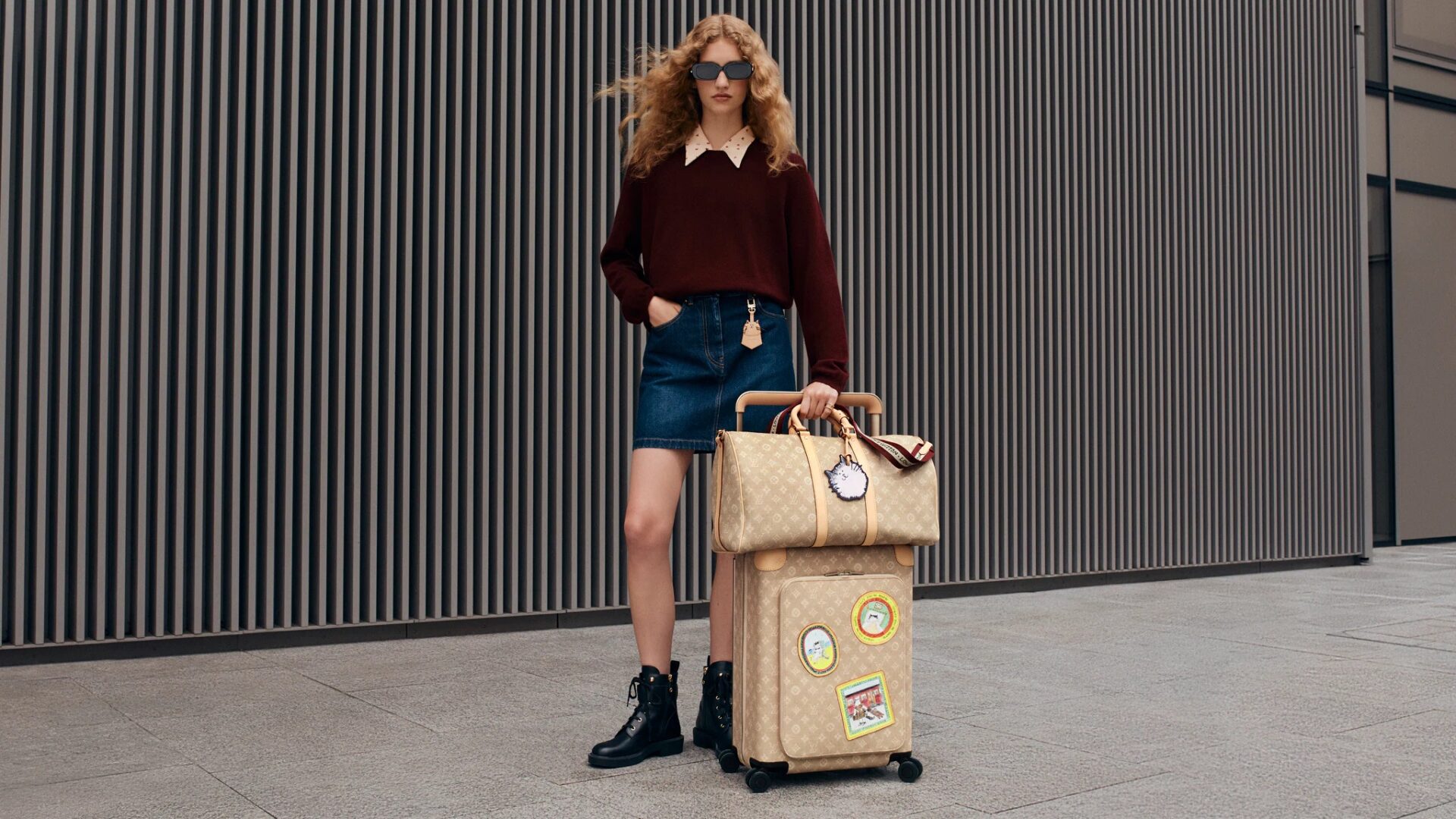A model carries Louis Vuitton luggage from the Louis Vuitton Travels with Grace Coddington collection