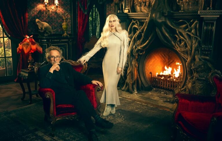 Lady Gaga and TIm Burton pose for a photoshoot next to a fireplace