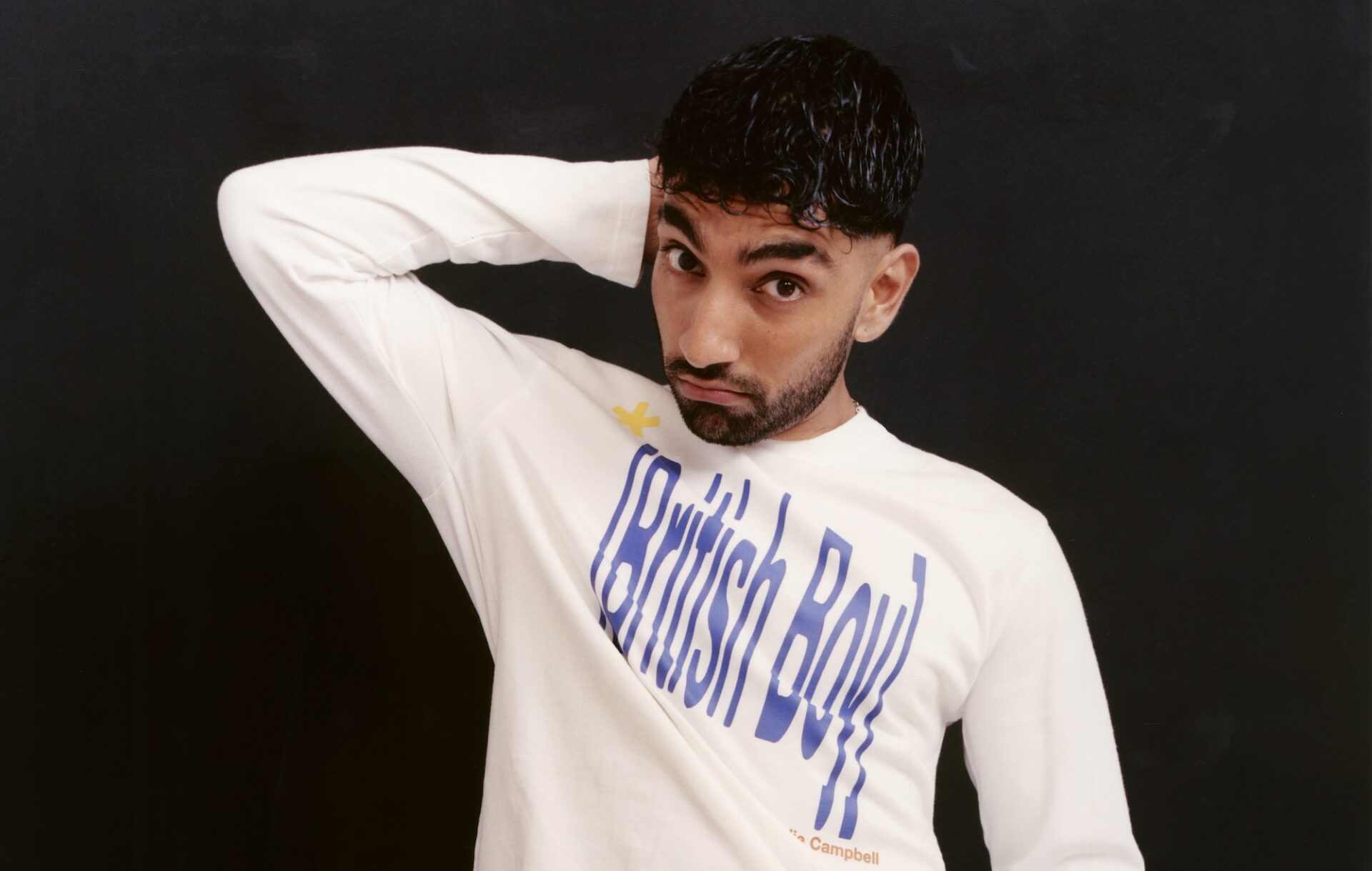 Mawaan Rizwan posing for a photoshoot in a t-shirt saying British Boy