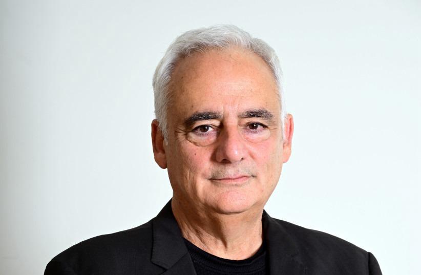 Head shot of a smiling man with a black blazer and T-shirt