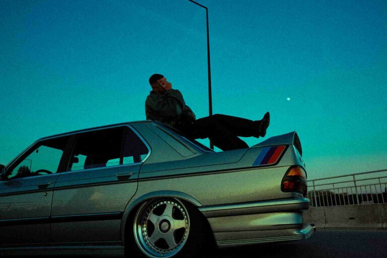 A man poses on a car for DJ Snake's Nomad cover
