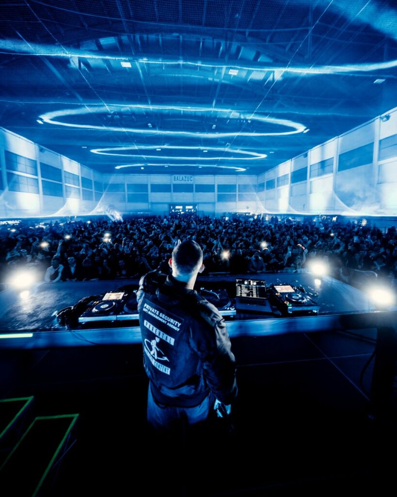 DJ SNake performs to a large crowd in an airport hangar
