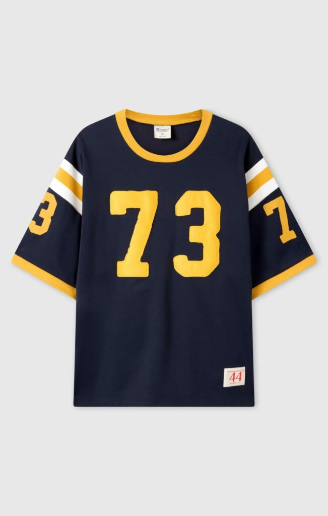 Product shot of retro-inspired Champion American football jersey with yellow numbers and trim 