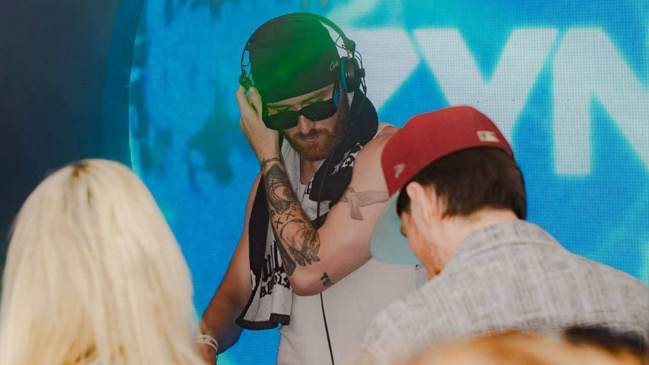 A DJ performing with the ZYN logo in the background